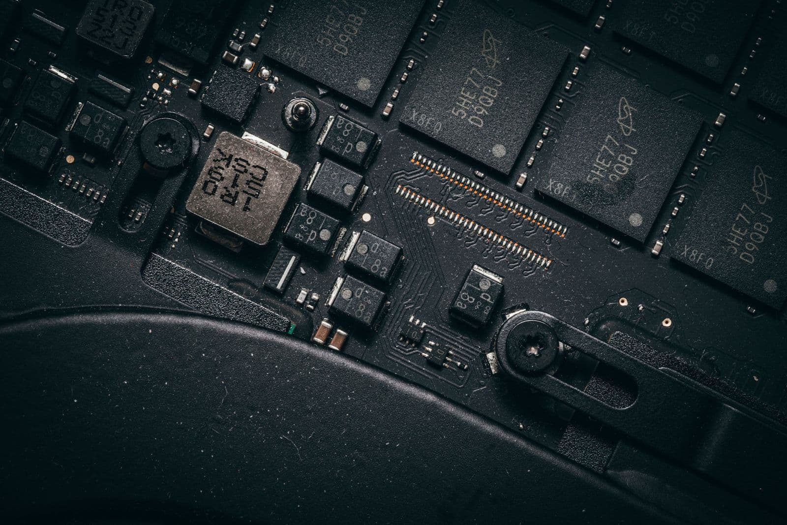Makroaufnahme eines Mainboards mit Speicherchips, Spule und SMD-Bauteilen
